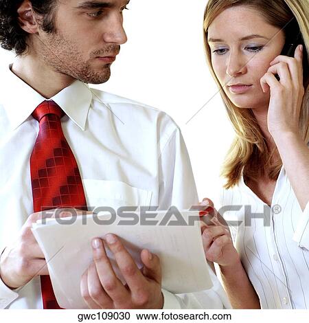 Stock Image - Businessman and a businesswoman discussing documents. Fotosearch