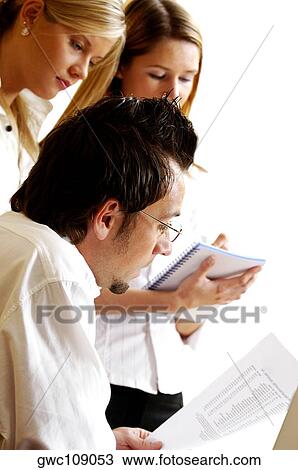 Stock Image - Businessman dictating to his secretaries. Fotosearch