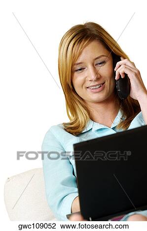 Close-up of a businesswoman talking on a mobile phone in front of a laptop View Large Photo Image Stock Image - Close-up of a businesswoman talking on a mobile phone in front of a laptop. Fotosearch