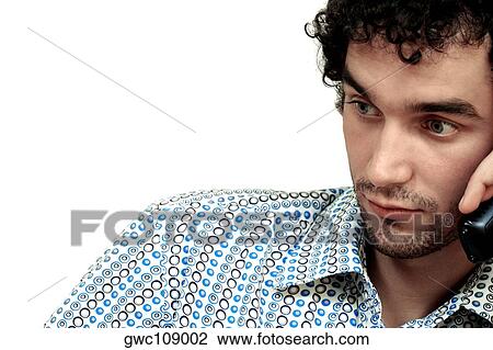 Close-up of a young man talking on a mobile phone View Large Photo Image Stock Image - Close-up of a young man talking on a mobile phone. Fotosearch