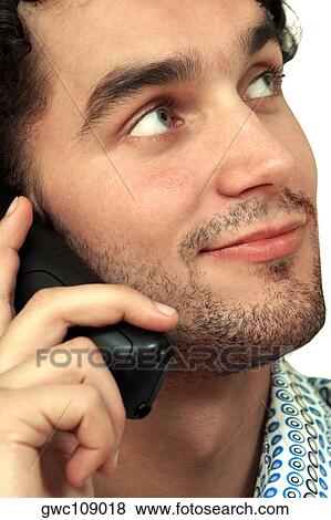 Close-up of a young man talking on a mobile phone View Large Photo Image Stock Photo - Close-up of a young man talking on a mobile phone. Fotosearch