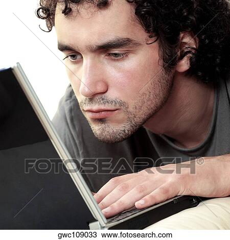 Close-up of a young man using a laptop View Large Photo Image Stock Image - Close-up of a young man using a laptop. Fotosearch