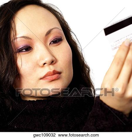 Stock Image - Close-up of a young woman holding a credit card. Fotosearch