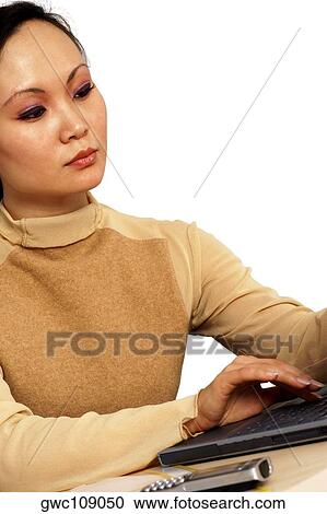 Stock Image - Close-up of a young woman working on a laptop. Fotosearch