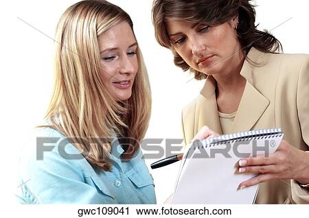 Close-up of two secretaries looking at a note pad View Large Photo Image Stock Image - Close-up of two secretaries looking at a note pad. Fotosearch