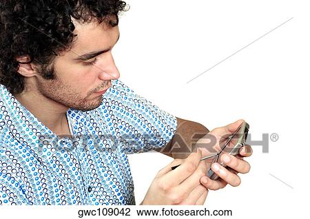 Stock Image - High angle view of a young man operating a personal data assistant. Fotosearch