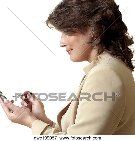 Stock Photo - Side profile of a businesswoman using a personal data assistant. Fotosearch
