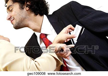 Young woman putting credit cards into young man's pocket View Large Photo Image Stock Photo - Young woman putting credit cards into young man's pocket. Fotosearch