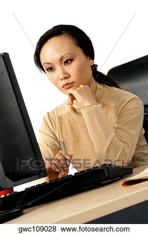 Young woman working on a computer View Large Photo Image Stock Photo - Young woman working on a computer. Fotosearch