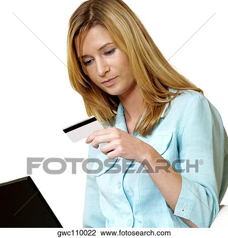 Businesswoman looking at a credit card on front of a laptop View Large Photo Image Stock Image - Businesswoman looking at a credit card on front of a laptop. Fotosearch