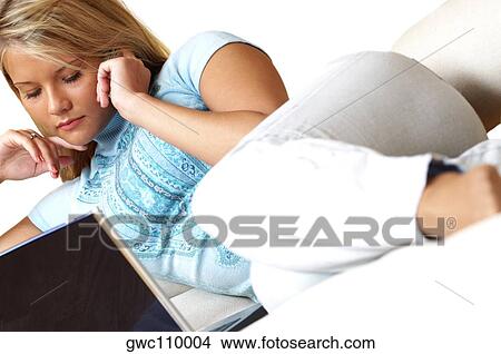 Picture - Businesswoman reclining in front of a laptop. Fotosearch