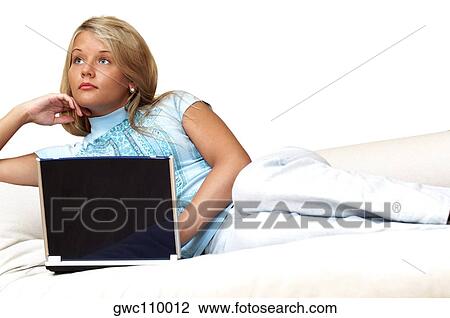 Stock Image - Businesswoman reclining in front of a laptop. Fotosearch
