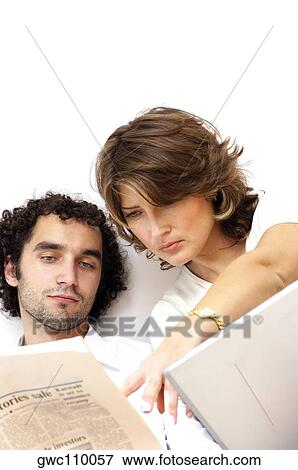 Close-up of a young couple reading a newspaper View Large Photo Image Stock Photo - Close-up of a young couple reading a newspaper. Fotosearch
