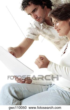 Stock Image - Close-up of a young couple reading documents. Fotosearch