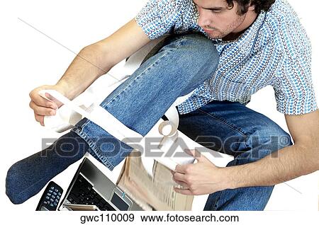 Close-up of a young man looking at a bill View Large Photo Image Stock Photo - Close-up of a young man looking at a bill. Fotosearch