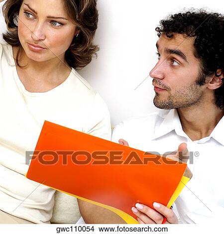 Close-up of a young man showing documents to a young woman View Large Photo Image Picture - Close-up of a young man showing documents to a young woman. Fotosearch