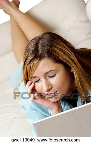 High angle view of a businesswoman lying on a couch in front of a laptop View Large Photo Image Stock Photo - High angle view of a businesswoman lying on a couch in front of a laptop. Fotosearch
