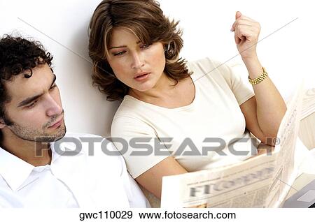 High angle view of a young couple reading a newspaper View Large Photo Image Stock Photo - High angle view of a young couple reading a newspaper. Fotosearch