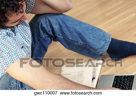 High angle view of a young man sitting in front of a laptop View Large Photo Image Stock Photo - High angle view of a young man sitting in front of a laptop. Fotosearch