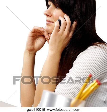 Stock Photography - Side profile of a businesswoman talking on a mobile phone. Fotosearch