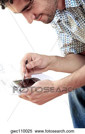 Side profile of a young man operating a personal data assistant View Large Photo Image Stock Photography - Side profile of a young man operating a personal data assistant. Fotosearch