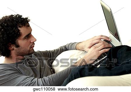 Side profile of a young man using a laptop View Large Photo Image Stock Photo - Side profile of a young man using a laptop. Fotosearch