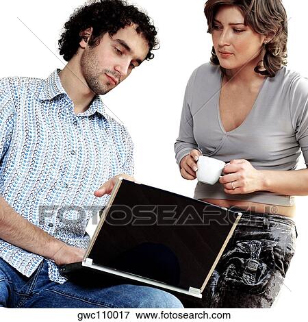 Young couple working on a laptop View Large Photo Image Stock Photo - Young couple working on a laptop. Fotosearch