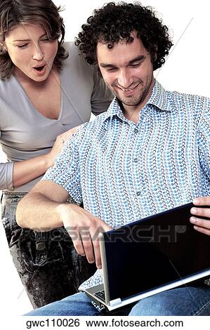 Young woman standing behind a young man working on a laptop View Large Photo Image Stock Photograph - Young woman standing behind a young man working on a laptop. Fotosearch