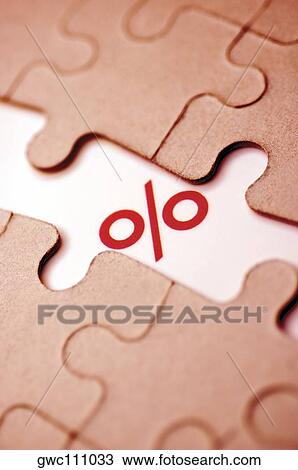 Stock Image - Close-up of a percentage sign and a jigsaw puzzle. Fotosearch