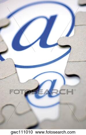 Stock Image - Close-up of jigsaw puzzle over an 'at' symbol. Fotosearch