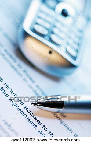 Stock Image - Close-up of a pen and a mobile phone on a document. Fotosearch