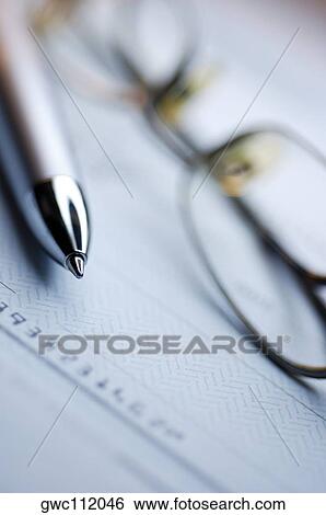 Stock Photograph - Pen and a pair of eyeglasses on a check. Fotosearch