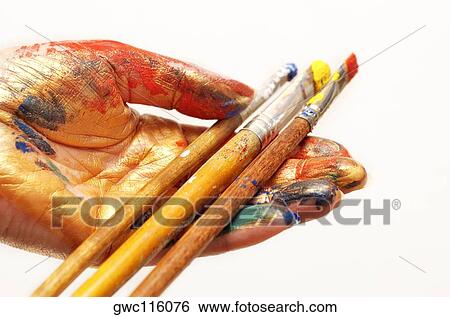 Stock Photograph - Close-up of paintbrushes in a person's hand. Fotosearch