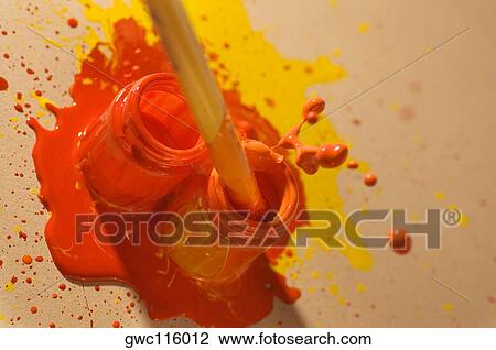 Stock Image - High angle view of a paintbrush dipped into a bottle of paint. Fotosearch