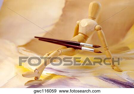 Paintbrushes on the lap of a wooden figurine View Large Photo Image Stock Photo - Paintbrushes on the lap of a wooden figurine. Fotosearch