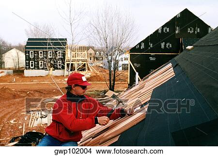 Man putting roof on new home View Large Photo Image Picture - Man putting roof on new home. Fotosearch