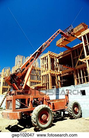 Tractor lifts lumber on construction site, clear blue sky in the background, in West Los Angeles, California View Large Photo Image Stock Photo - Tractor lifts lumber on construction site, clear blue sky in the background, in West Los Angeles, California. Fotosearch