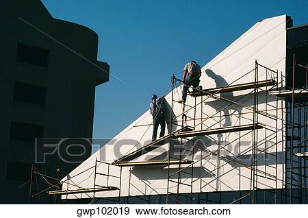 Stock Photo - Workers instaling panel for Wostwood building 1. Fotosearch