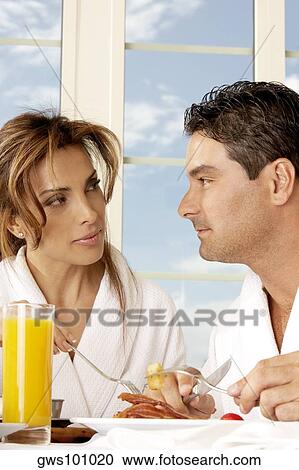 Stock Image - Close-up of a mid adult couple having breakfast and looking at each other. Fotosearch
