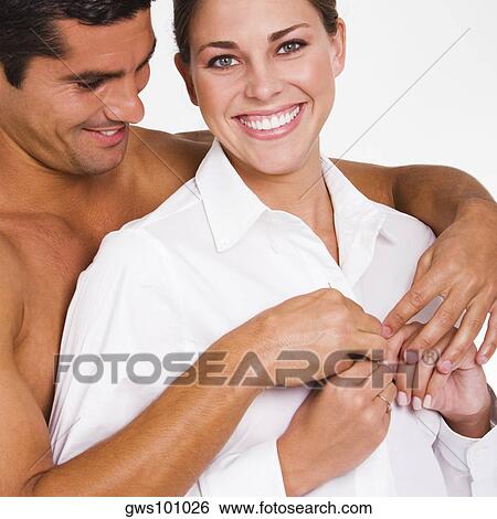 Close-up of a mid adult man buttoning a young woman's shirt View Large Photo Image Stock Photograph - Close-up of a mid adult man buttoning a young woman's shirt. Fotosearch
