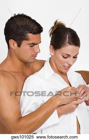 Close-up of a mid adult man buttoning a young woman's shirt View Large Photo Image Stock Photography - Close-up of a mid adult man buttoning a young woman's shirt. Fotosearch