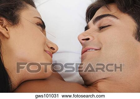 Close-up of a young couple lying on the bed looking at each other View Large Photo Image Stock Image - Close-up of a young couple lying on the bed looking at each other. Fotosearch