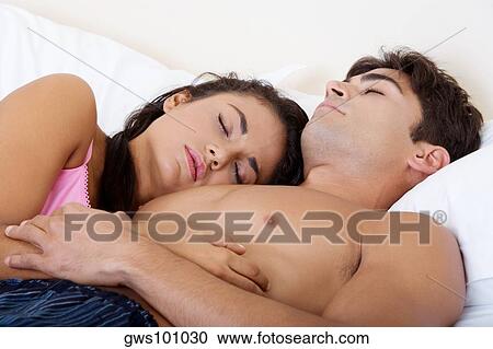 Close-up of a young couple sleeping on a bed View Large Photo Image Stock Image - Close-up of a young couple sleeping on a bed. Fotosearch