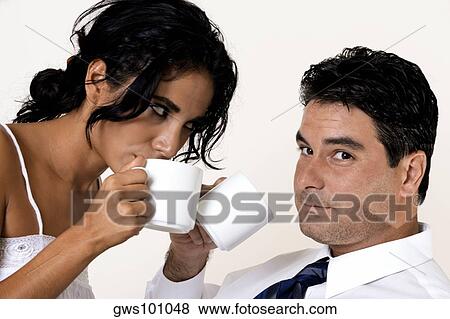 Close-up of a young woman and a mid adult man drinking coffee View Large Photo Image Stock Photo - Close-up of a young woman and a mid adult man drinking coffee. Fotosearch