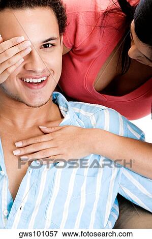 Close-up of a young woman covering a young man's eyes View Large Photo Image Stock Photo - Close-up of a young woman covering a young man's eyes. Fotosearch
