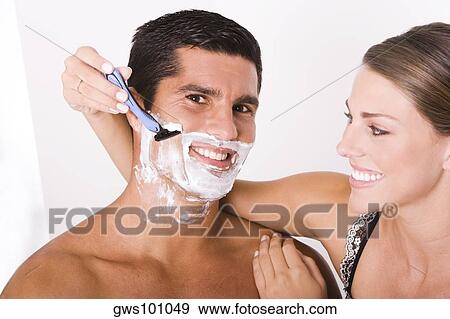 Close-up of a young woman shaving a mid adult man View Large Photo Image Stock Photo - Close-up of a young woman shaving a mid adult man. Fotosearch