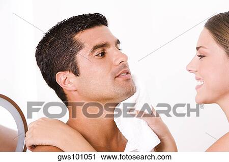 Close-up of a young woman wiping a mid adult man's face with a towel View Large Photo Image Stock Image - Close-up of a young woman wiping a mid adult man's face with a towel. Fotosearch