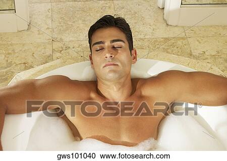 High angle view of a bare chested young man lying in a bathtub with his eyes closed View Large Photo Image Stock Image - High angle view of a bare chested young man lying in a bathtub with his eyes closed. Fotosearch