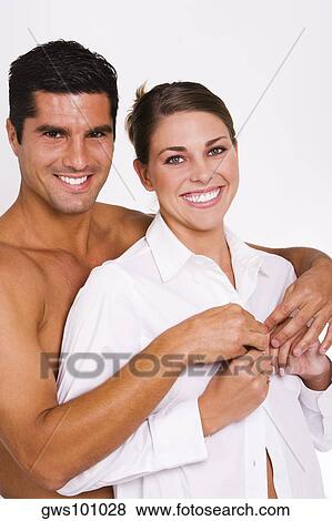 Portrait of a mid adult man buttoning a young woman's shirt View Large Photo Image Stock Photo - Portrait of a mid adult man buttoning a young woman's shirt. Fotosearch