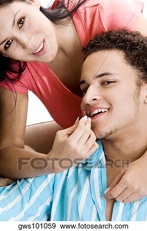 Stock Photo - Portrait of a young woman feeding grapes to a young man. Fotosearch